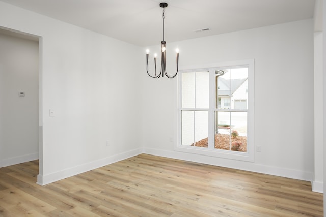 unfurnished dining area featuring a notable chandelier and light hardwood / wood-style floors