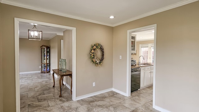 hallway with ornamental molding, a sink, and baseboards