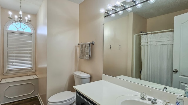 full bathroom with a textured ceiling, toilet, a shower with shower curtain, vanity, and an inviting chandelier