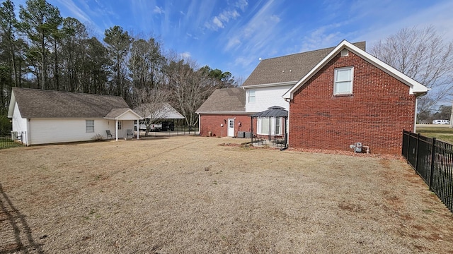 rear view of property featuring a patio area, brick siding, fence, and a gazebo