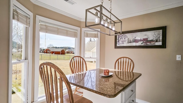 dining room featuring ornamental molding, visible vents, a notable chandelier, and baseboards