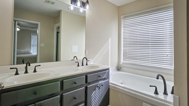 bathroom with a garden tub, double vanity, a sink, and visible vents