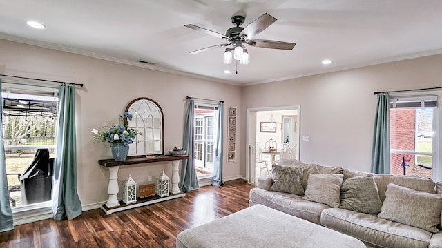 living room featuring ornamental molding, wood finished floors, visible vents, and a ceiling fan