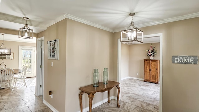 hall featuring crown molding, baseboards, and a notable chandelier