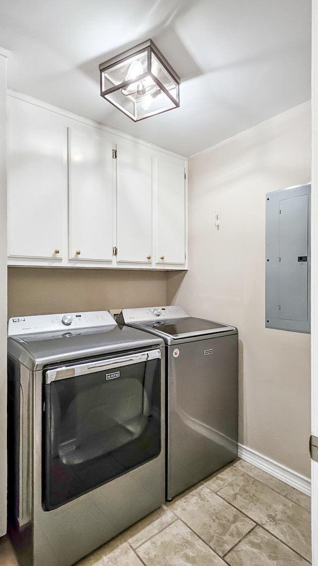 laundry room with washing machine and dryer, electric panel, cabinet space, and baseboards