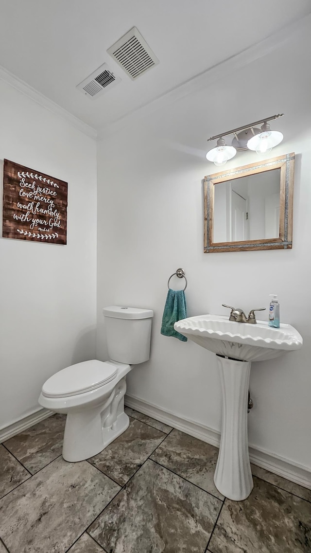 bathroom with ornamental molding, baseboards, visible vents, and toilet