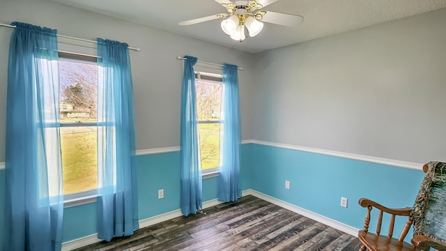 unfurnished room with dark wood-type flooring, baseboards, and a ceiling fan