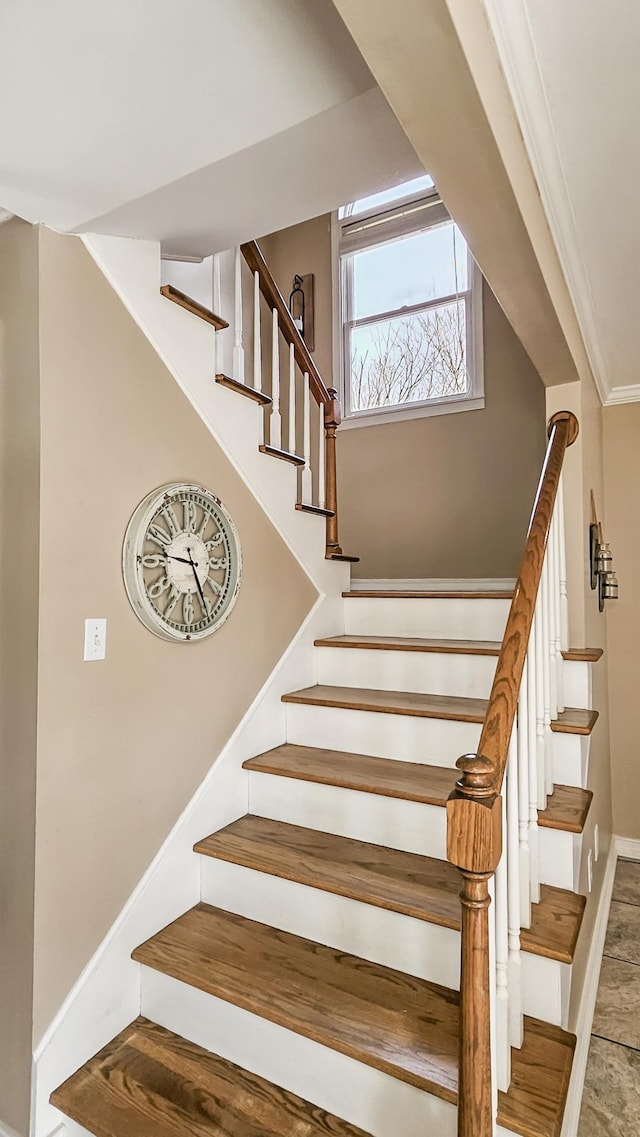 stairs with ornamental molding and baseboards