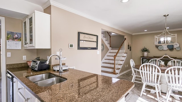 kitchen featuring ornamental molding, white cabinetry, and a sink