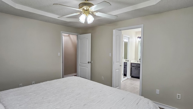 bedroom featuring a textured ceiling, ceiling fan, light tile patterned flooring, and connected bathroom