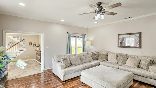 living room with ornamental molding, visible vents, stairs, and wood finished floors