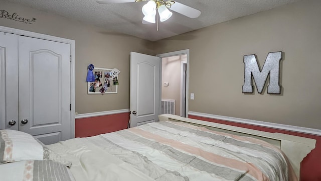 bedroom with a ceiling fan, visible vents, and a textured ceiling