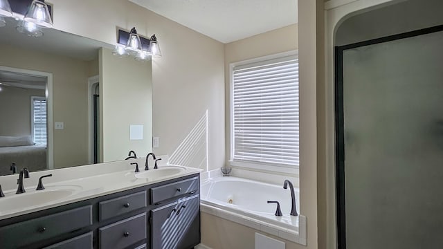 bathroom featuring a whirlpool tub, a shower stall, double vanity, and a sink