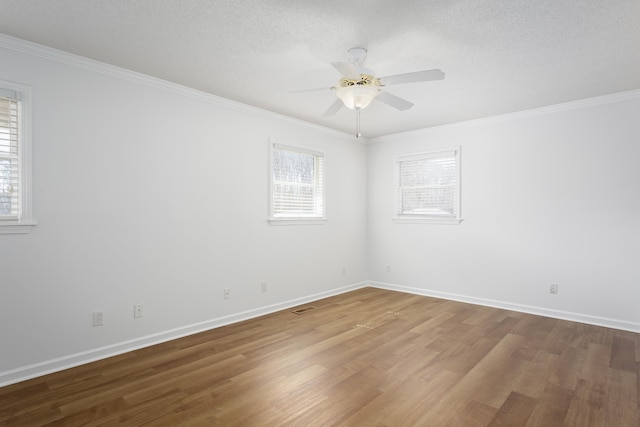 spare room with ornamental molding, ceiling fan, baseboards, and wood finished floors