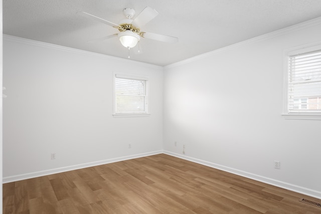 unfurnished room with ceiling fan, crown molding, baseboards, and wood finished floors