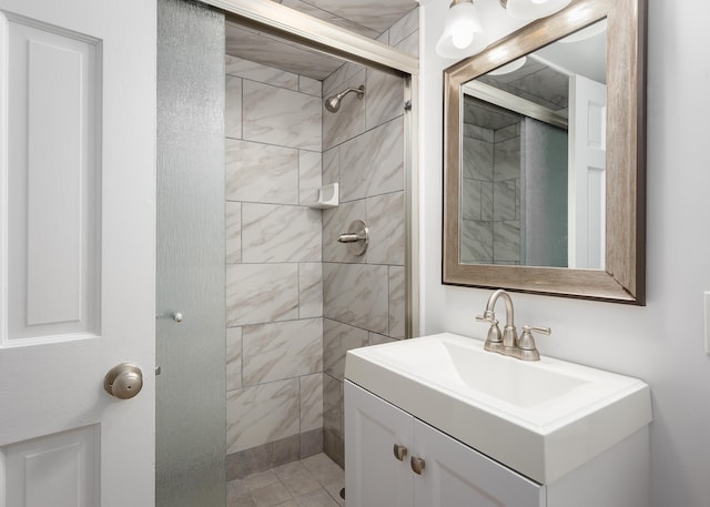 full bathroom featuring tiled shower and vanity