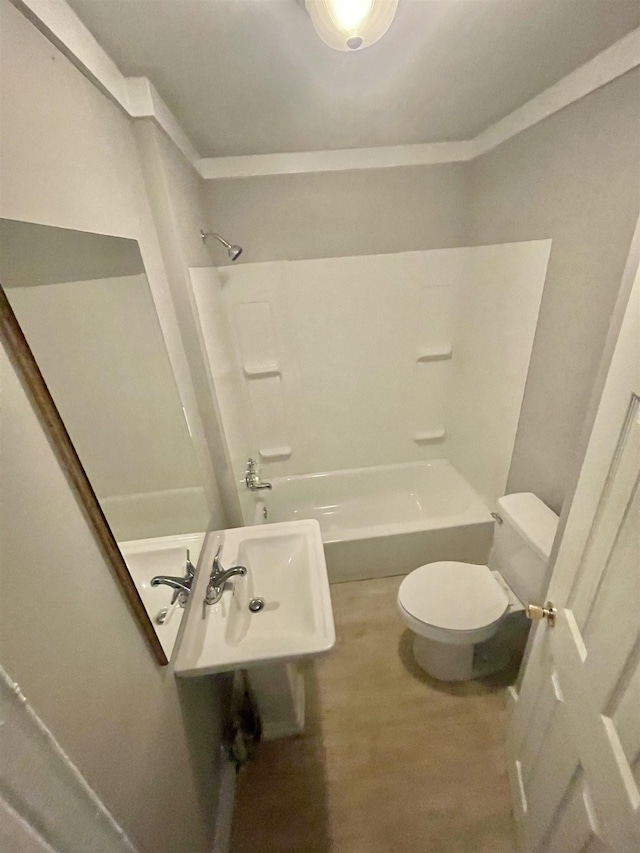 bathroom with washtub / shower combination, a sink, and toilet