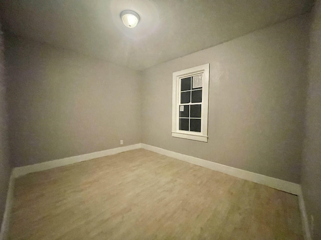 empty room featuring baseboards and wood finished floors