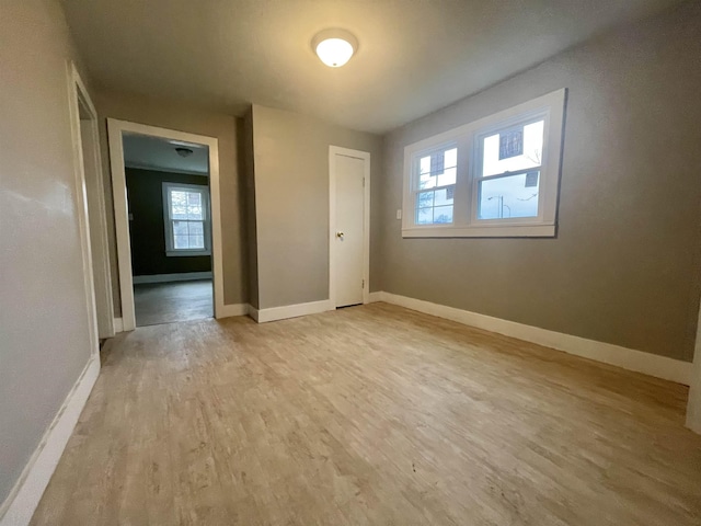 unfurnished bedroom featuring light wood-style floors and baseboards