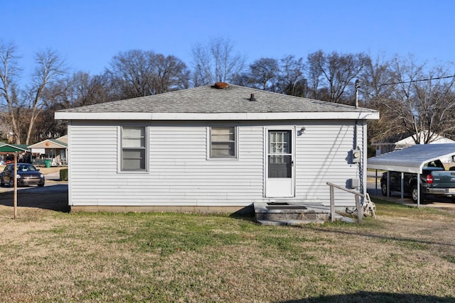 back of property featuring a carport and a lawn