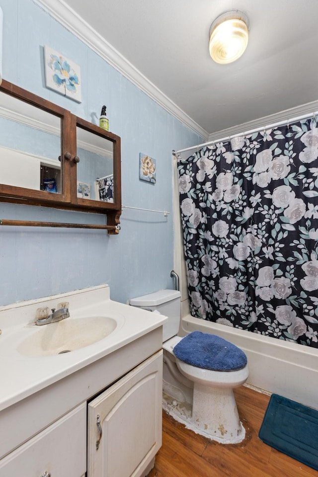 full bathroom featuring vanity, shower / tub combo with curtain, crown molding, hardwood / wood-style flooring, and toilet