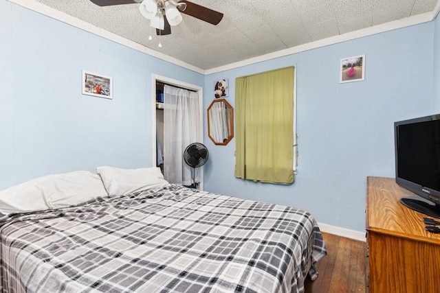 bedroom featuring a closet, ceiling fan, crown molding, and hardwood / wood-style flooring