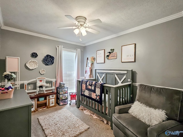 bedroom with carpet flooring, ceiling fan, ornamental molding, a textured ceiling, and a crib