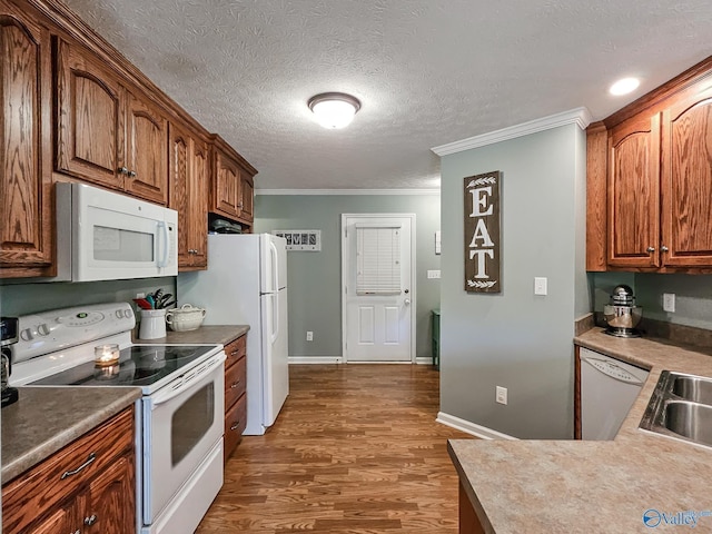 kitchen with white appliances, dark wood-type flooring, sink, ornamental molding, and a textured ceiling