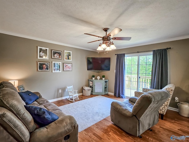 living room with ceiling fan, crown molding, a textured ceiling, and hardwood / wood-style flooring