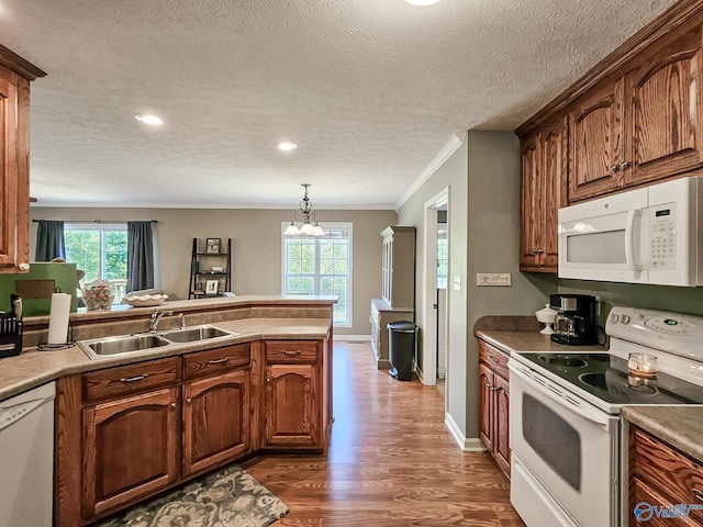 kitchen with sink, a chandelier, a textured ceiling, white appliances, and ornamental molding