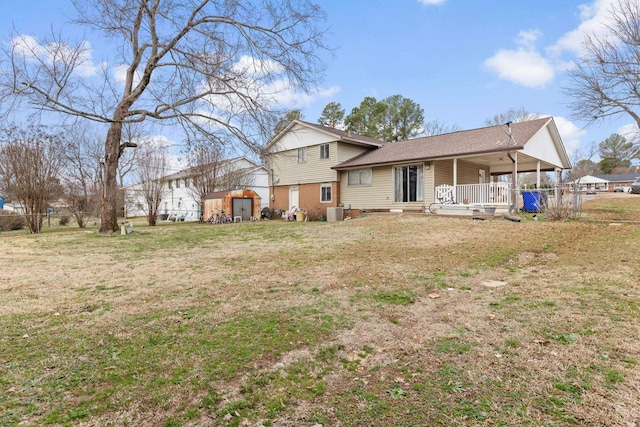 back of property with a yard, covered porch, and a shed