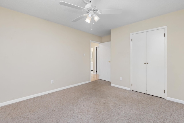 unfurnished bedroom with light colored carpet, a closet, and ceiling fan