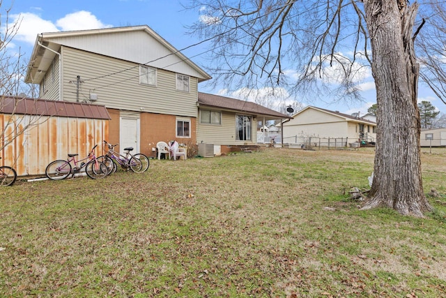 rear view of property featuring a lawn