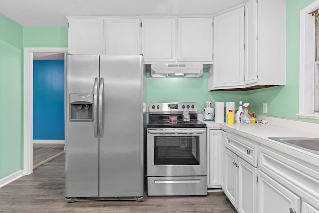 kitchen with appliances with stainless steel finishes, dark wood-type flooring, and white cabinets