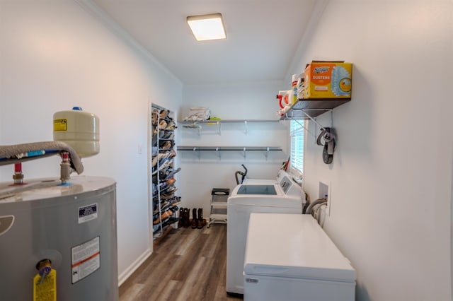 washroom featuring dark hardwood / wood-style flooring, ornamental molding, washing machine and dryer, and water heater