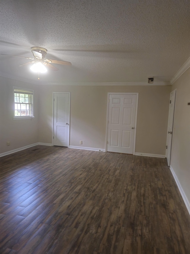  - empty room with a textured ceiling, dark wood-type flooring, a ceiling fan, crown molding, and baseboards