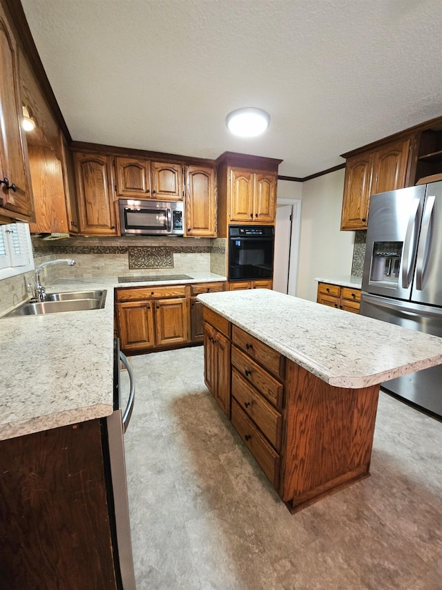  - kitchen featuring black appliances, a sink, light countertops, decorative backsplash, and crown molding