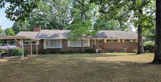 - ranch-style home featuring brick siding, a chimney, a front lawn, and a carport