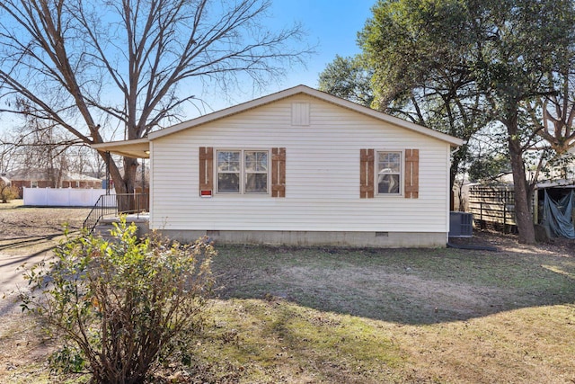 view of home's exterior with cooling unit and a yard