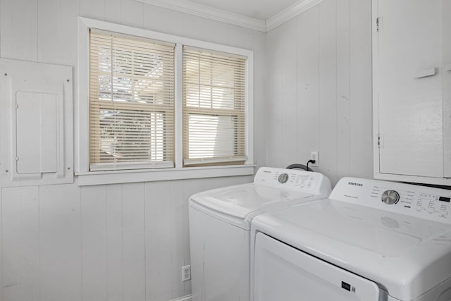 laundry room featuring ornamental molding, wood walls, washing machine and clothes dryer, and electric panel