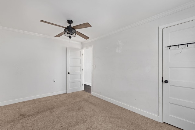 carpeted empty room featuring crown molding and ceiling fan