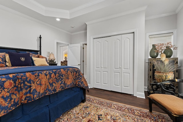 bedroom with a raised ceiling, dark hardwood / wood-style flooring, a closet, and ornamental molding