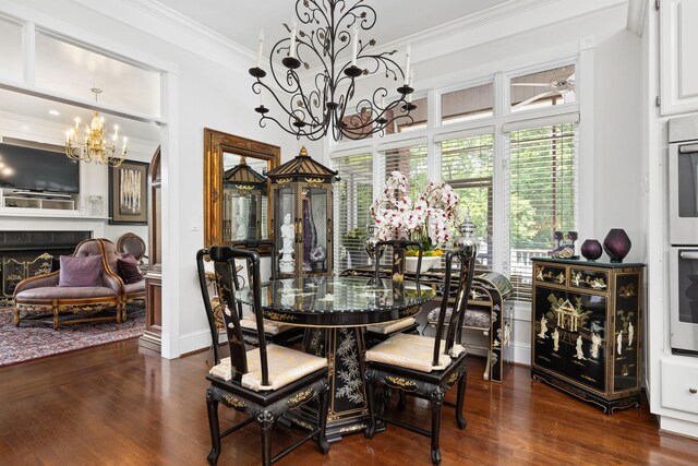 dining room with a notable chandelier, dark hardwood / wood-style floors, ornamental molding, and a tile fireplace