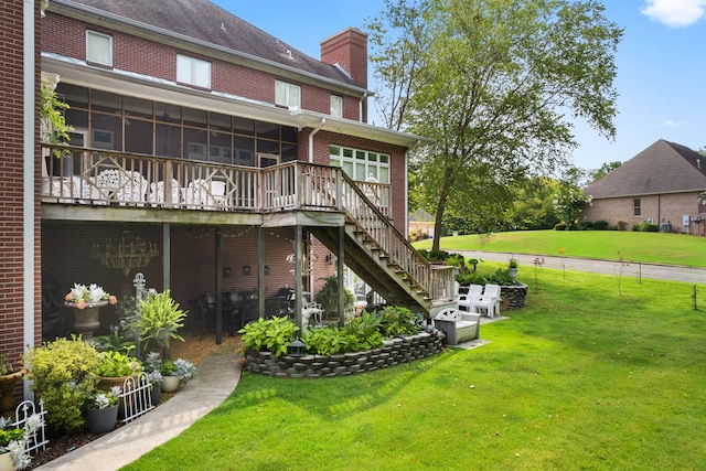 rear view of property featuring a yard and a sunroom