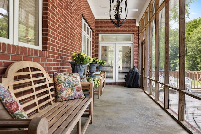 sunroom / solarium featuring french doors and an inviting chandelier