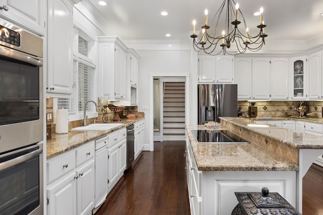 kitchen featuring a kitchen island, sink, white cabinetry, and stainless steel appliances