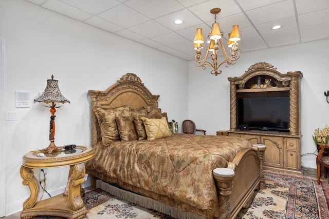 bedroom with a notable chandelier and a drop ceiling