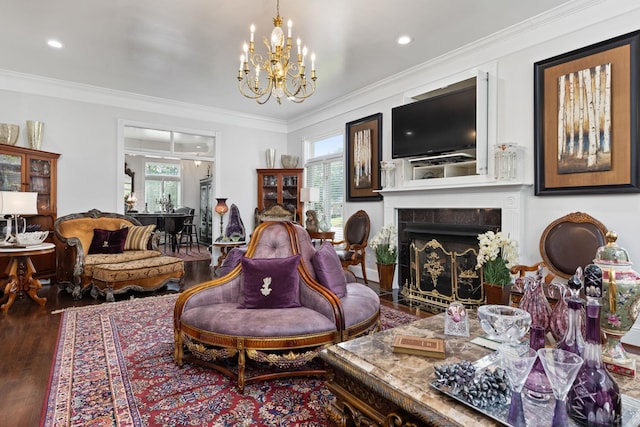 sitting room with a fireplace, hardwood / wood-style floors, a chandelier, and ornamental molding