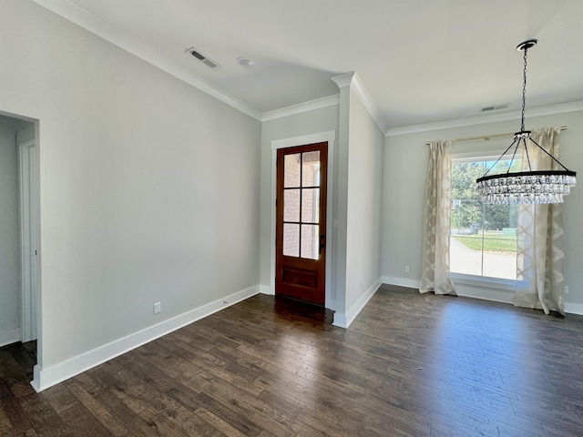 foyer with dark hardwood / wood-style floors, ornamental molding, and a chandelier