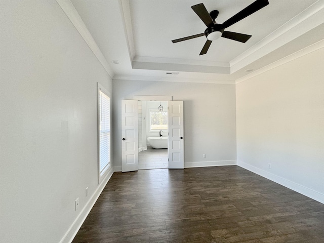 unfurnished bedroom with ceiling fan, dark hardwood / wood-style flooring, a raised ceiling, and ornamental molding